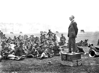 The Australian Prime Minister, Right Honourable William Morris (Billy) Hughes (standing on four ammunition boxes), addressing Australians, about one and a half miles from Amiens.